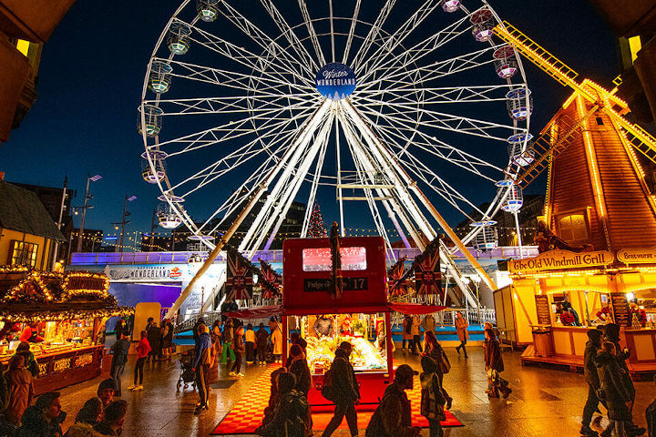 A festive winter scene showing Old Market Square in Nottingham decorated with Christmas lights and market stalls